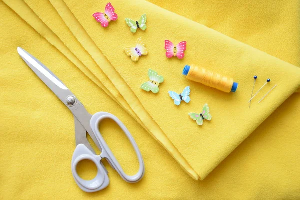 Dikiş için kumaş ve aksesuarlar, dikiş işleri, arka plan, parlak sarı renk, terzi makası, kelebek düğmeleri, iplikler ve iğneler, doku, el yapımı, tasarım, kavramsal fotoğraf, desen
