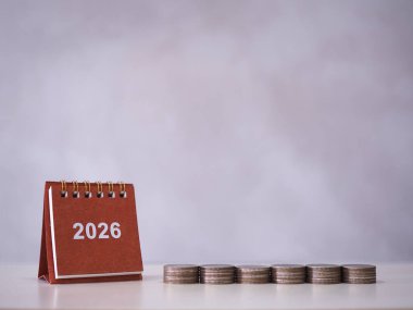 2026 masa takvimi ve bozuk para yığını. 2026 yılında para, finans, yatırım ve işletme tasarruf kavramı büyüyor