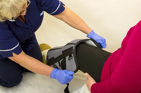 A compression therapy leg brace is fitted to a hospital patient following  knee surgery. It is used in hospitals for the prevention of DVT or Deep  Stock Photo - Alamy