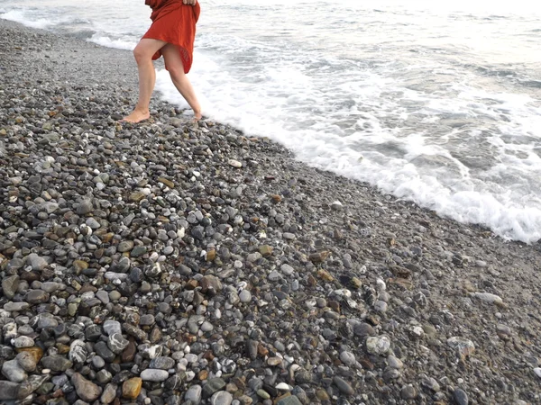 Девушка босиком на берегу в красной юбке — стоковое фото