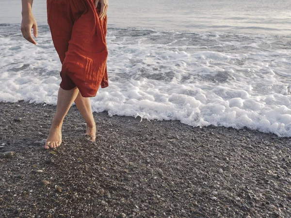 Woman in bare legs walking on the shore — Stock Photo, Image