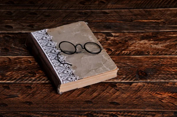 Old book and vintage round reading glasses
