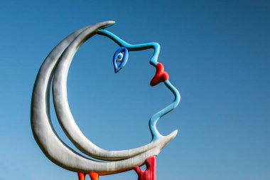 Bir kadının yüzünün gökyüzüne baktığı hilal şeklindeki ayın sanatsal farkındalığı.