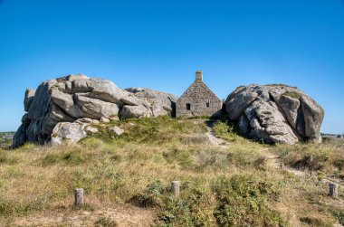 Meneham Sahil Güvenlik Evi (Corps de Garde), Meneham, Kerlouan, Brittany, Fransa 'da iki büyük granit kaya kütlesi arasında yer alan ikonik bir taş ev..