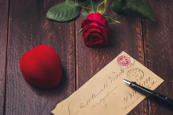 Red rose on old love letter concept on wood table Stock Obrázky