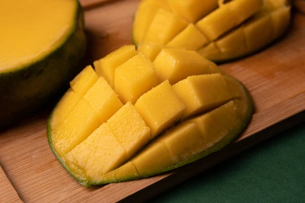 Bir arka plan kompozisyon olarak kahverengi renkli ahşap tahta yüzey üzerinde yalan olgun mango meyve