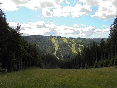 124 yazında kayak yamacında panoramik uzun mesafe manzarası; 124 yazında doğa manzarası; 124yazında bulutlar ve tepeler sertçe güneş ışığı altında; 124 dağ çayırı ve ormanlar
