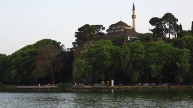 Bu, Ioannina Gölü 'ndeki bir Türk camii. Gölün kenarındaki bir tekne ve trafiğin çok güzel bir görüntüsü..