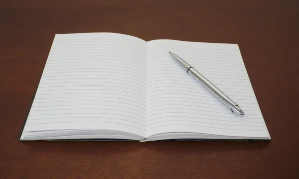 Kalem kağıt açık defter üzerinde