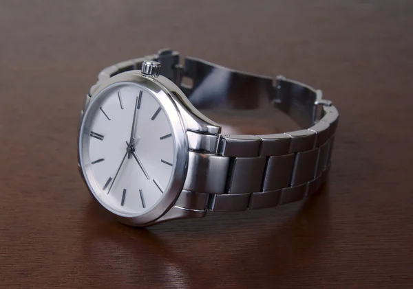 Ahşap masa üzerinde Gümüş Kol saati