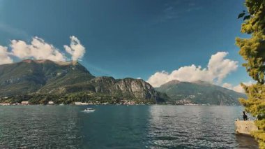 Bulutlu Como Gölü panoraması zamanı. Suyun üzerinde beyaz bulutlar hareket ediyor. Dağ Gölü 'ndeki değişen hava koşulları.