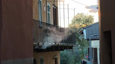 Kuzey İtalya 'daki ev bacasından beyaz duman yükseliyor. Geceleri şömineli ya da sobalı ısıtma..