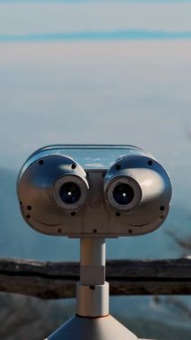 İtalyan dağlarındaki turizm platformunda mavi gökyüzüne karşı bulutları gösteren dürbünler..