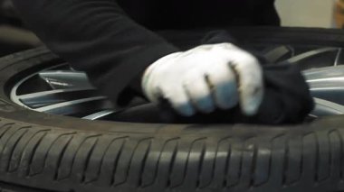 Profesyonel işçi servis istasyonunda metal tekerleği aletle temizliyor. Araba lastiği bakımı ve montaj hazırlıkları.