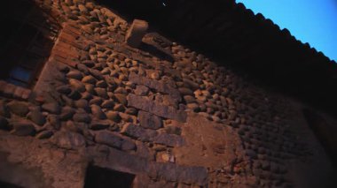 Gece ışıklarıyla aydınlanan antik İtalyan kalesinin taş kulesi karanlık gökyüzüne karşı.