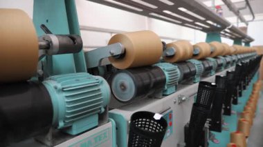 Ağır tekstil fabrikası ekipmanları yüksek hassasiyet ve hız ile bobinleri geri sarar.