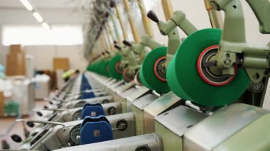 Modern bir endüstriyel fabrikada otomatik tekstil makineleri iplikleri geri sarar. Üretim hattı ayrıntıları.