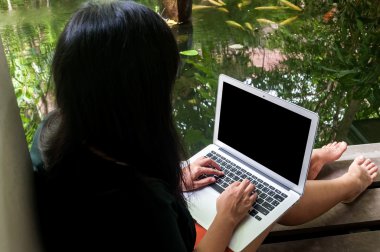 Kadın arkadaşları evinde havuz kenarında bir dizüstü bilgisayar ile sohbet