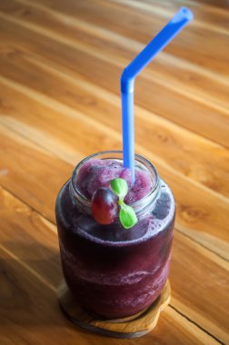 Ahşap masa üzerinde bir şekilde dekore edilmiş cam dondurulmuş üzüm suyu