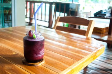 Ahşap masa üzerinde bir şekilde dekore edilmiş cam dondurulmuş üzüm suyu