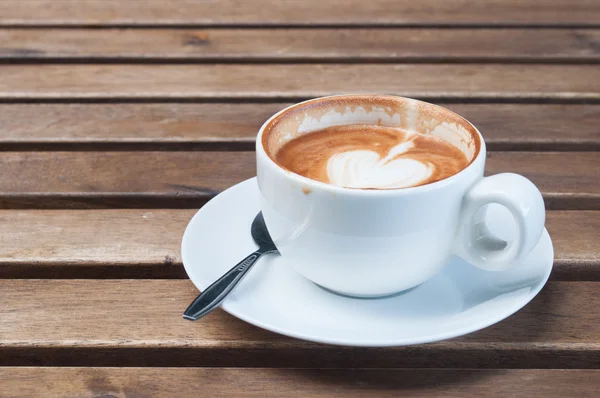 Xícara de café com colher na mesa de madeira — Fotografia de Stock