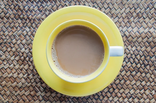 Xícara amarela de café no fundo do weave, vista superior — Fotografia de Stock