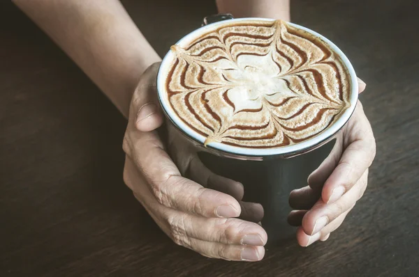 Beker van caramel latte koffie in vrouwelijke hand — Stockfoto
