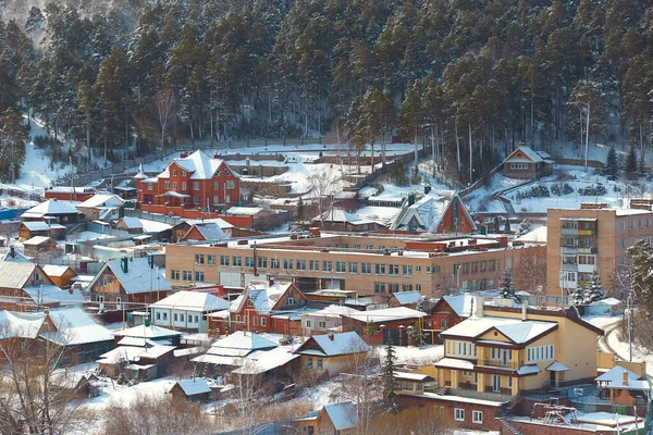 Russian Village in winter. Mountain view of the village and the village school building.