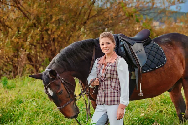 彼女の馬と古典的なトラックスーツのライダーの美しい女の子の肖像画 — ストック写真