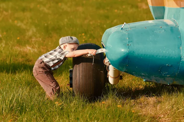 Un niño tiene curiosidad por el diseño del avión. El concepto de elegir una profesión futura —  Fotos de Stock