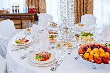 Güzel dekore edilmiş yemek sofrası farklı atıştırmalıklar ve aperatiflerle kurumsal bir partide taze meyveler ya da düğün kutlaması..