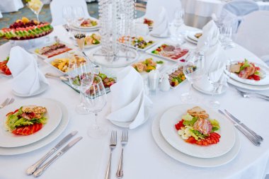 Güzel dekore edilmiş yemek sofrası farklı atıştırmalıklar ve aperatiflerle kurumsal bir partide taze meyveler ya da düğün kutlaması..