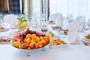 Güzel dekore edilmiş yemek sofrası farklı atıştırmalıklar ve aperatiflerle kurumsal bir partide taze meyveler ya da düğün kutlaması..