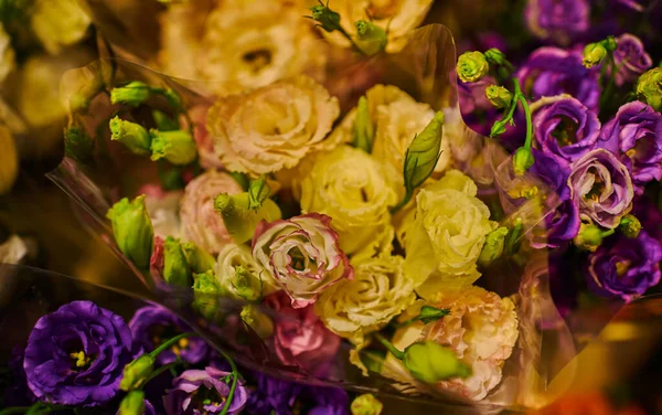 Beautiful bouquets of mixed flowers in a flower shop. A bright mix of flowers. Background on full screen. Handsome fresh bouquets. Flowers delivery. Floral shop concept. Selective focus.