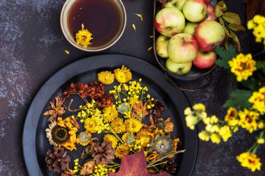 Sonbahar, sonbahar yaprakları, çiçekler, elmalar ve fincan çay. Ahşap kırsal arka planda sonbahar çiftliği hasadı. Tonu ayarlanmış resim.