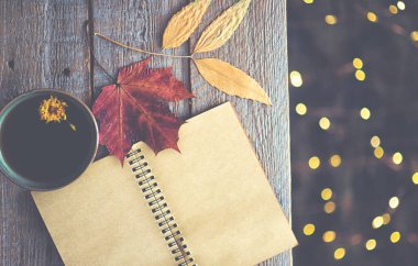 Sonbahar hala hayattır. Eski model defter, kuru yapraklar ve sıcak çay. Tonlanmış görüntü. Düz konum, üst görünüm, kopyalama alanı.