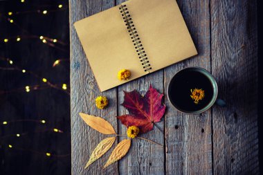 Sonbahar hala hayattır. Eski model defter, kuru yapraklar ve sıcak çay. Tonlanmış görüntü. Düz konum, üst görünüm, kopyalama alanı.