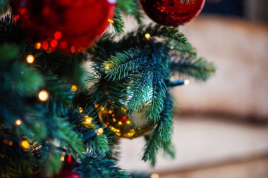 Bulanık arka planda dekore edilmiş Noel ağacı. Çam ağacının dallarında asılı Noel süsleme topları ve fotokopi alanının soyut arka planına sahip süsler..