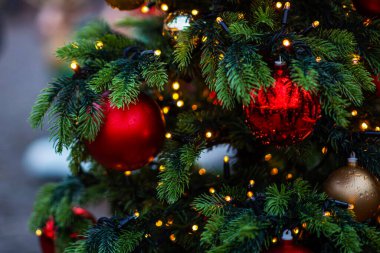 Bulanık arka planda dekore edilmiş Noel ağacı. Yılbaşı ve Noel tatili arka planında ağaçta ışıklar.