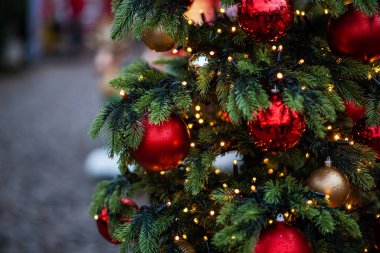 Bulanık arka planda dekore edilmiş Noel ağacı. Yılbaşı ve Noel tatili arka planında ağaçta ışıklar.