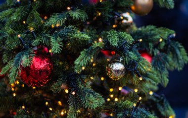 Bulanık arka planda dekore edilmiş Noel ağacı. Yılbaşı ve Noel tatili arka planında ağaçta ışıklar.