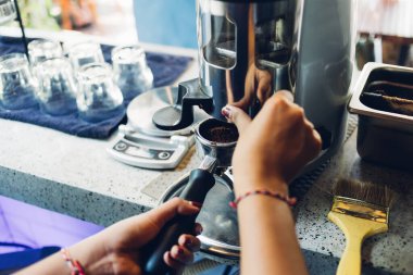 Kahve makinesinden dökülen espresso yakın plan. Profesyonel kahve demleme. Dipsiz filtresi olan profesyonel kahve makinesinden kahve çıkarma..