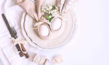 Paskalya yumurtaları ve ahşap masadaki sevimli tavşancık. Şenlik dekorasyonu. Mutlu Paskalyalar! Paskalya arkaplanını tebrik ederim. Paskalya yumurtaları ve bahar çiçekleri. Kopyalama alanı olan üst görünüm.