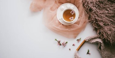 Elma ağacı çiçekli bir fincan çay. Beyaz bir fincanda, çiçekli beyaz bir tahta masada bitki çayı. Çay seremonisi. Uzayı kopyala Seçici odak.