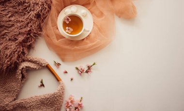 Elma ağacı çiçekli bir fincan çay. Beyaz bir fincanda, çiçekli beyaz bir tahta masada bitki çayı. Çay seremonisi. Uzayı kopyala Seçici odak.