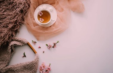 Elma ağacı çiçekli bir fincan çay. Beyaz bir fincanda, çiçekli beyaz bir tahta masada bitki çayı. Çay seremonisi. Uzayı kopyala Seçici odak.