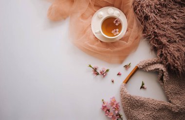 Elma ağacı çiçekli bir fincan çay. Beyaz bir fincanda, çiçekli beyaz bir tahta masada bitki çayı. Çay seremonisi. Uzayı kopyala Seçici odak.