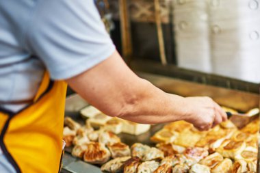 Yemek kamyonunda yağda kızartılmış börek isteyen bir kadın. Yemek kamyonu satıcısının müşteriye servis ettiği sokağı kapatın. Asya sokak yemekleri, yemek servisi..