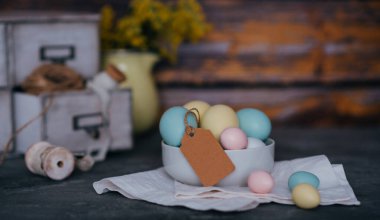 Ahşap arka planda Paskalya yumurtaları. Bahar tatilleri için klasik bahar arkaplanı. Renkli Paskalya yumurtaları ve bahar çiçekleriyle Paskalya kompozisyonu.