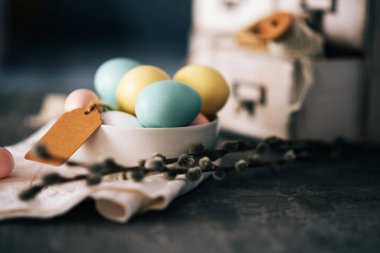 Ahşap arka planda Paskalya yumurtaları. Bahar tatilleri için klasik bahar arkaplanı. Renkli Paskalya yumurtaları ve bahar çiçekleriyle Paskalya kompozisyonu.